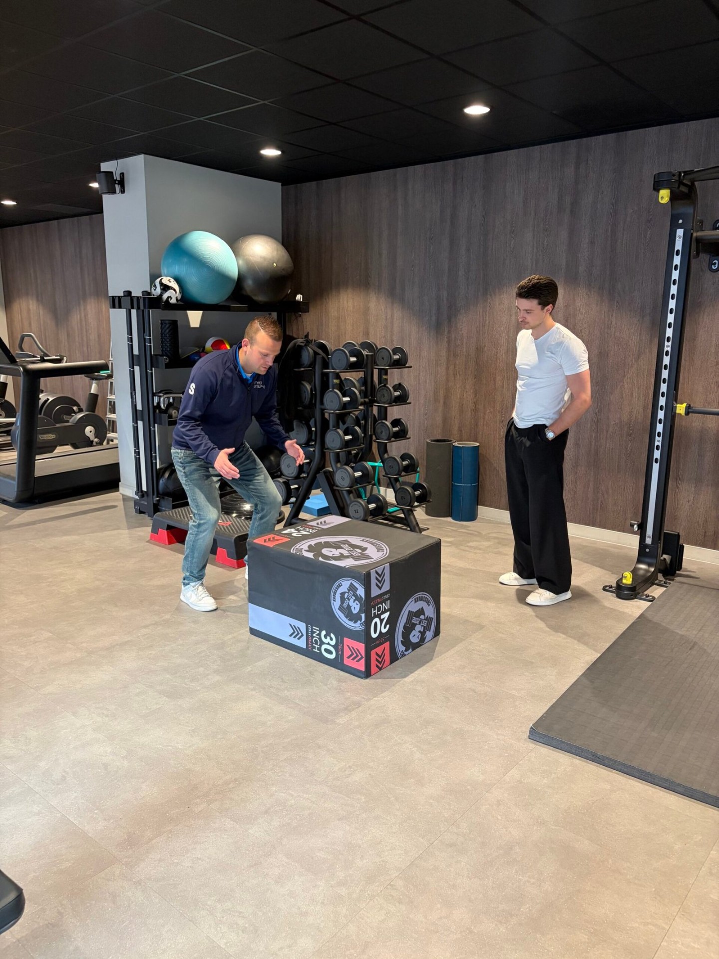 Fysiotherapeut legt oefening uit aan patiënt in de oefenruimte van Fysiotherapie Strijp-S Eindhoven